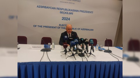 Səs vermək üçün növbə gözləyən insanların üzlərində təbəssüm var idi