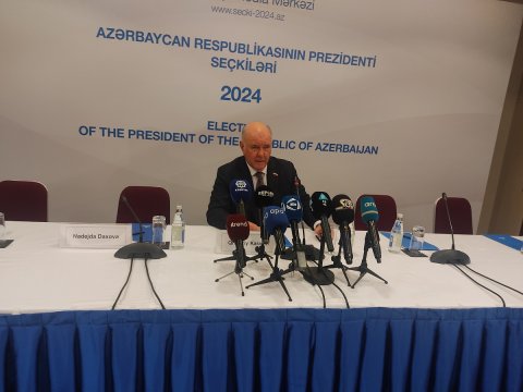 Səs vermək üçün növbə gözləyən insanların üzlərində təbəssüm var idi