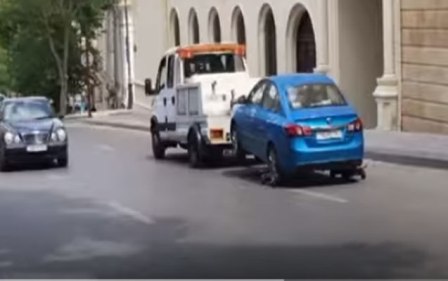 Evakuator avtomobili sürüyərək cərimə meydançasına aparır - Video 
